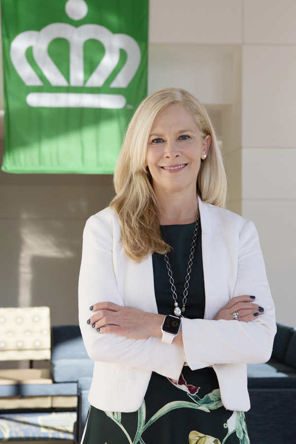 Alyson Craig standing in an Office with UNCC Crown Banner Behind her